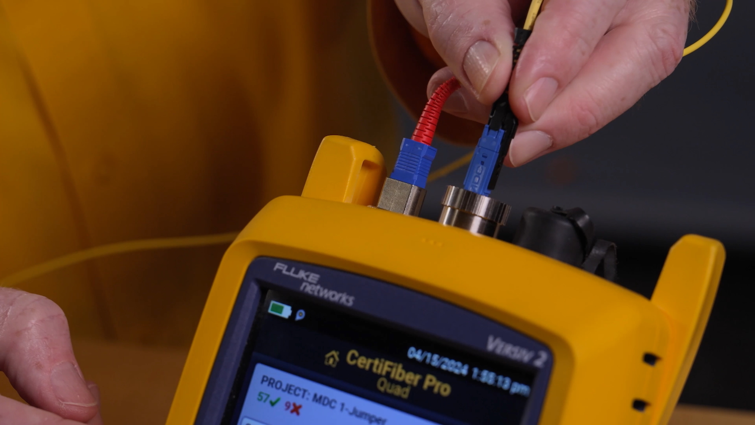 Plugging an MDC link into the top of a yellow CertiFiber Pro device.